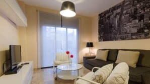 Ein modernes Wohnzimmer mit einer Couch, einem Couchtisch, einem Fernseher und einem Gemälde an der Wand.