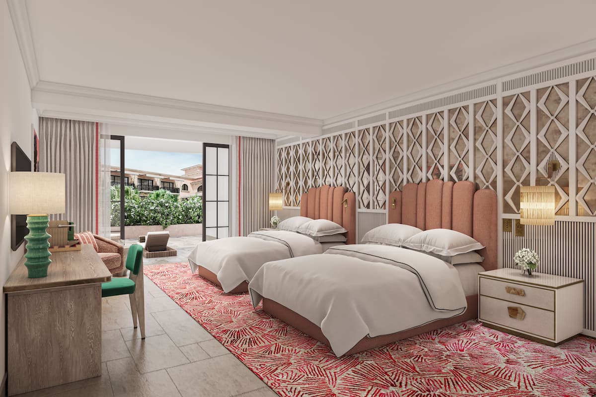 A modern hotel room with two beds, a desk, and a view of the outdoor area.