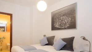 A bedroom with a bed, two pillows, a bedside lamp, and a framed picture on the wall. - Duque 4 · Standard Apartment without Terrace · 2 Bedrooms · 2 Bathrooms (Córdoba)