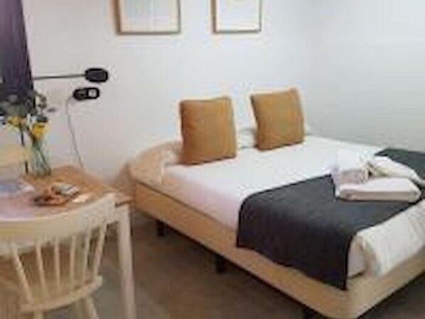 A neatly arranged hotel room with a bed, a bedside table, and a chair. - Casa del Río 1 · Standard Studio without terrace · 1 Bed · 1 Bathroom (Córdoba)