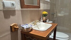 Une salle de bain avec un lavabo, un miroir et une douche.