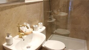 Ein Badezimmer mit Waschbecken, Toilette und Duschkabine.