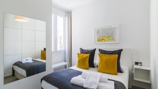 A modern hotel room with a large bed, a bedside table, a mirror, and a window. - Tendillas 5 · Apartment · 2 bedrooms · 1 sofa bed · 2 bathrooms (Córdoba)
