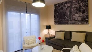 A living room with a sofa, a chair, a small table, and a lamp. - Duque 1 · Apartment with Terrace · 2 Bedrooms · 2 Bathrooms (Córdoba)