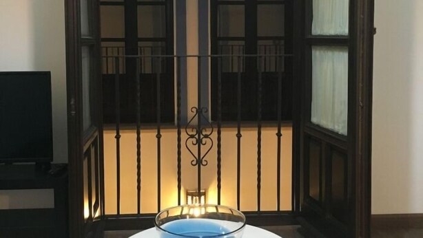A room with a large window, a small table with a glass bowl, and a television on a stand. - Casa del Río 4 · Standard Studio without terrace · 1 Bed · 1 Bathroom (Córdoba)
