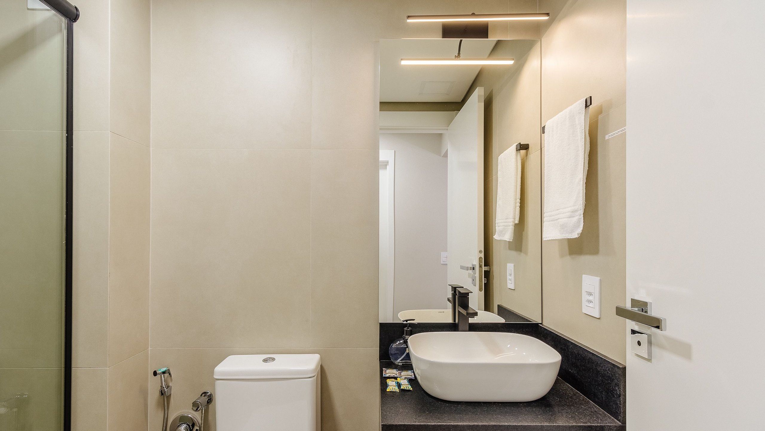 Un baño moderno con inodoro, lavabo y ducha.