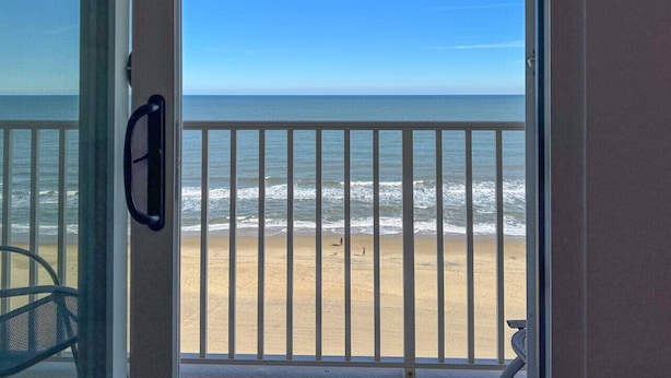 Un balcon avec vue sur la plage et l’océan.