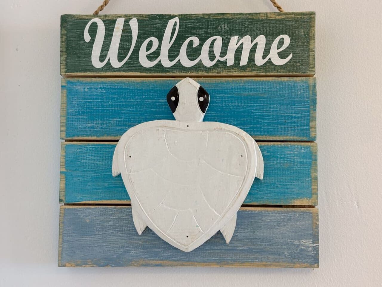 A wooden sign with a heart-shaped cutout and the word "Welcome" above it.