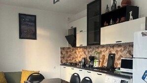 Une cuisine compacte comprenant une table à manger, des chaises, un lave-linge et un four à micro-ondes.