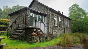 Une maison en pierre avec un escalier en pierre et un petit porche.
