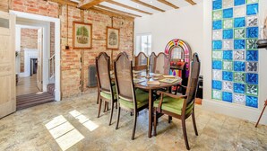 Un espace repas agrémenté d’un mur en briques, de poutres en bois, d’un juke-box et d’un mur décoré de mosaïques.