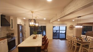 A spacious kitchen with a large island, modern appliances, and a view to the outside. - Sunset Paradise on Lake Michigan (Charlevoix)