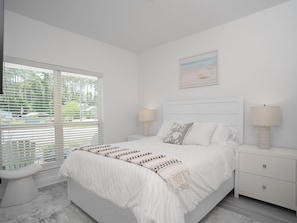 A bedroom with a bed, two bedside tables, a window with blinds, a nightstand, and a painting on the wall. - Cozy 4-bedroom house near top beaches in fantastic Santa Rosa (Santa Rosa)