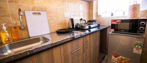 Apartemen Deluks | Dapur pribadi | Lemari es, microwave, peralatan masak/sendok-piring, dan meja makan