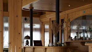 A wooden interior with a dining area, a staircase, and a reception desk. - Hotel Belfiore (Dimaro Folgarida)