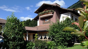 A two-story hotel with a balcony garden, a traditional roof, and a view of a mountain. - Hotel Belfiore (Dimaro Folgarida)