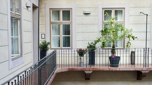 A multi-level building with balconies, potted plants, and a brick floor. - Harmonia Palace - Historic Residence (Budapest)