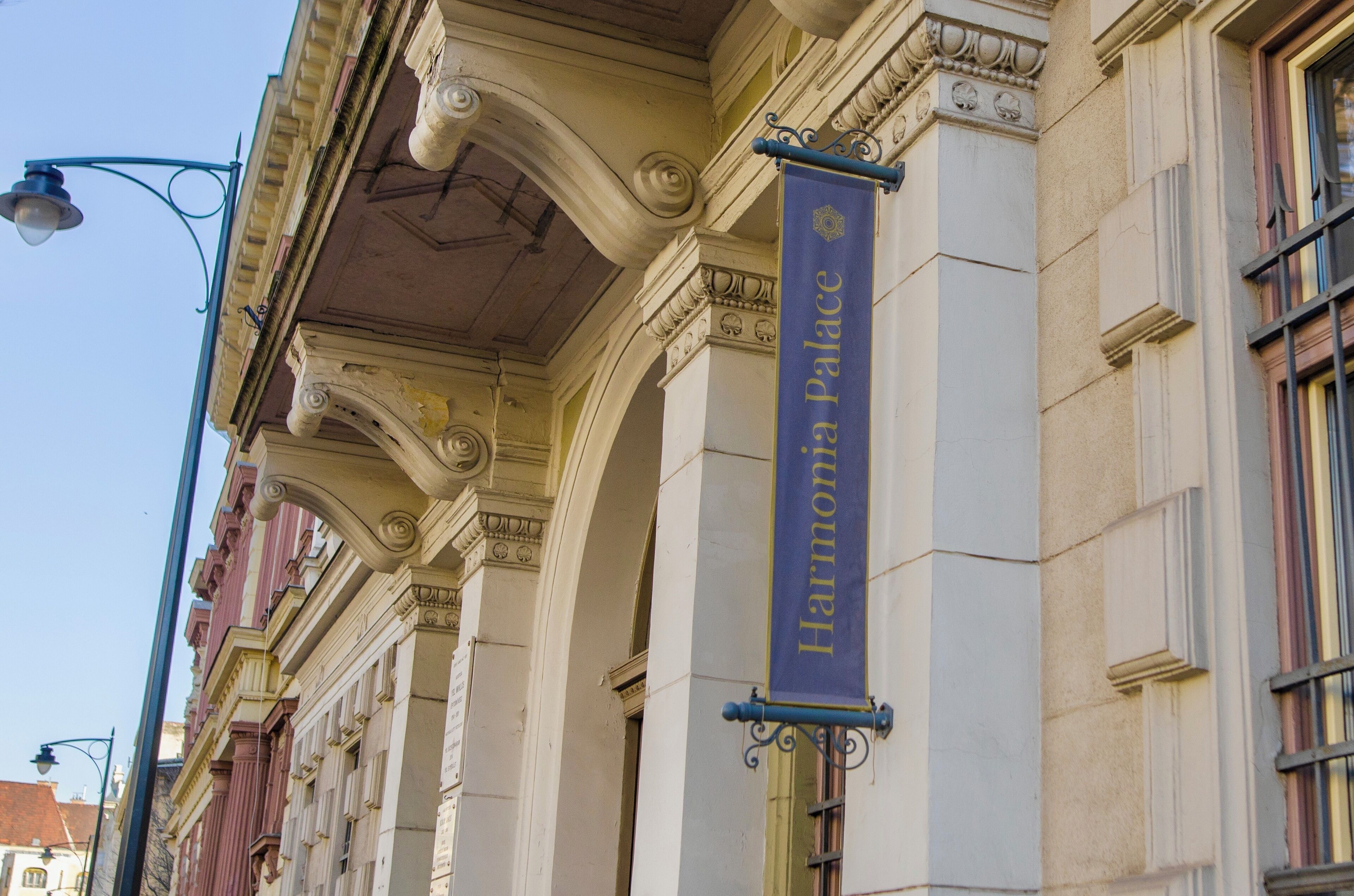 Fachada de un edificio con un cartel que dice 'Harmonia Palace'.