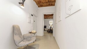 Un intérieur moderne aux couleurs neutres, avec un canapé minimaliste et un plafond en bois.