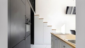Eine moderne Küche mit dunklen Schränken, einer Holz Arbeitsplatte und einem Edelstahl-Spülbecken.