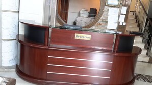Un mostrador de recepción con superficie de vidrio y un letrero que dice 'Reception'.