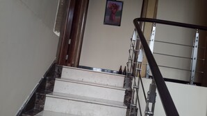 Una escalera con barandilla de metal y un cuadro colgado en la pared.