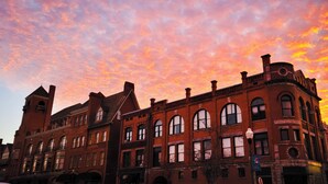 A historic building with multiple stories and arched windows, featuring a prominent clock tower and a large central entrance. - Cozy Camper 2-bedroom RV in Americus GA  (Americus)