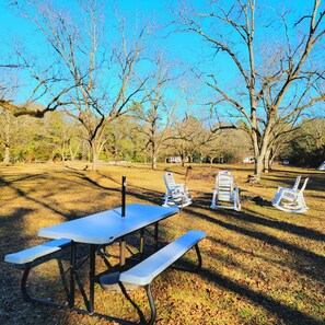 A picnic area with a table and benches, surrounded by leafless trees. - Cozy Camper 2-bedroom RV in Americus GA (Americus)