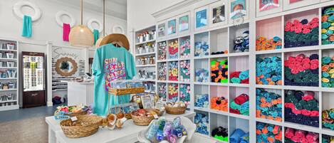 A brightly lit store with shelves of colorful merchandise and a display table with various items.