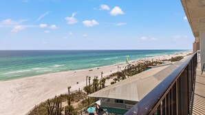 A beach view from a balcony with a clear sky, sandy beach, and ocean. - Sandpiper Beacon Beach Resort (Panama City Beach)