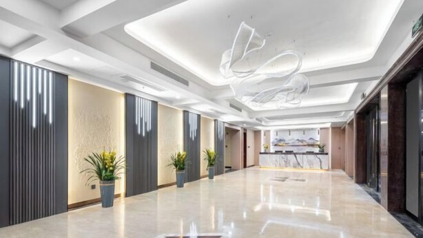 Eine geräumige Lobby mit poliertem Boden, modernem Deckenstil und Topfpflanzen.