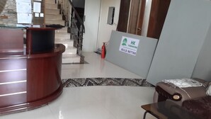 Un área de recepción con un escritorio de madera, un extintor, una escalera y un letrero con el texto "HK Formwork Build Better".