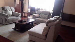 Un salón con dos sofás, una mesa de centro y una mesita auxiliar.