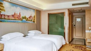 A hotel room with two beds, a painting of a cityscape, a green door, and a carpet with floral patterns. - Vienna 3 Best Hotel (Shanghai Qiantan Expo Sanlin) (Shanghai)