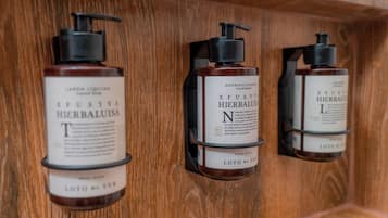 Tres estantes de madera con botellas de productos para el cuidado del cabello.