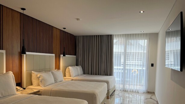 A hotel room with two beds, a large mirror, and a view of the city. - Hotels 111 (San Andrés)