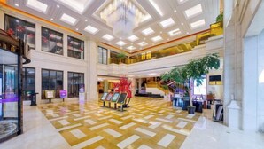 A spacious lobby with a high ceiling, multiple floors, and a central atrium with a large plant. - Hangzhou Fuyang Yaoyue International Hotel (Enbo Avenue) (Hangzhou)
