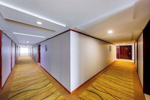 A hotel corridor with carpeted floors, doors on both sides, and a long hallway leading to a room. - Hangzhou Fuyang Yaoyue International Hotel (Enbo Avenue) (Hangzhou)