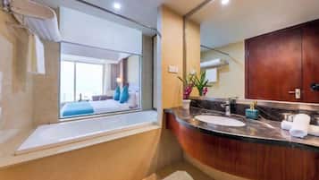 Un baño moderno con un espejo grande, una bañera y un lavamanos con lavabo.