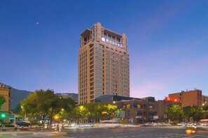 Un hotel su più piani con una posizione d'angolo ben visibile, ampie finestre e un ingresso evidente.
