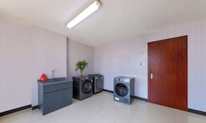 A compact laundry room with a washing machine, dryer, and a small sink area. - Hangzhou Fuyang Yaoyue International Hotel (Enbo Avenue) (Hangzhou)