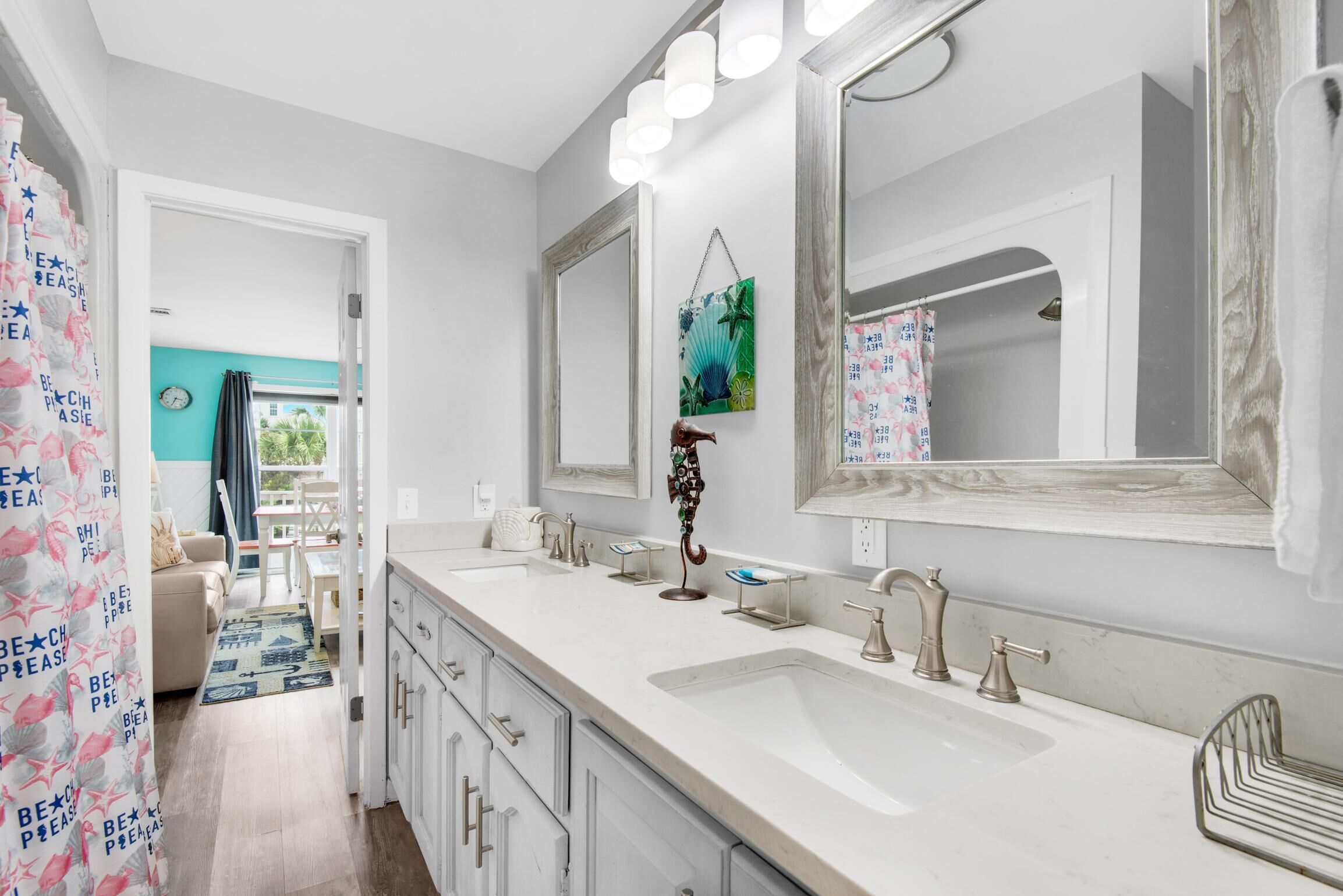 A modern bathroom with a large mirror, two sinks, and a shower area.