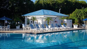 A pool area with lounge chairs and a covered pavilion.