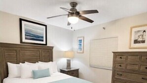 A bedroom with a bed, a dresser, a ceiling fan, and a window with blinds. - 2BR w/ Ocean Views, Pool, Beach, Near Pennekamp Park (Tavernier)