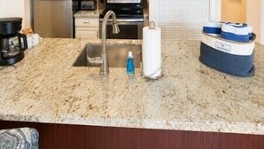 A compact kitchen with a granite countertop, stainless steel appliances, and a white door. - 2BR w/ Ocean Views, Pool, Beach, Near Pennekamp Park (Tavernier)