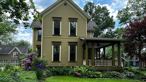 A two-story house with a covered porch and a well-maintained garden.