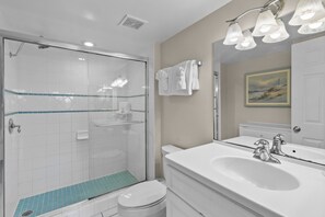 A bathroom with a shower, toilet, sink, and a mirror with lights. - 2BR Condo w/ Ocean Views, Private Beach & Pool (Tavernier)