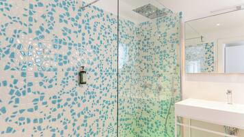 A bathroom with a glass shower enclosure and a white sink.
