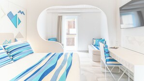 Una habitación de hotel moderna con una cama, un escritorio y vistas al exterior.