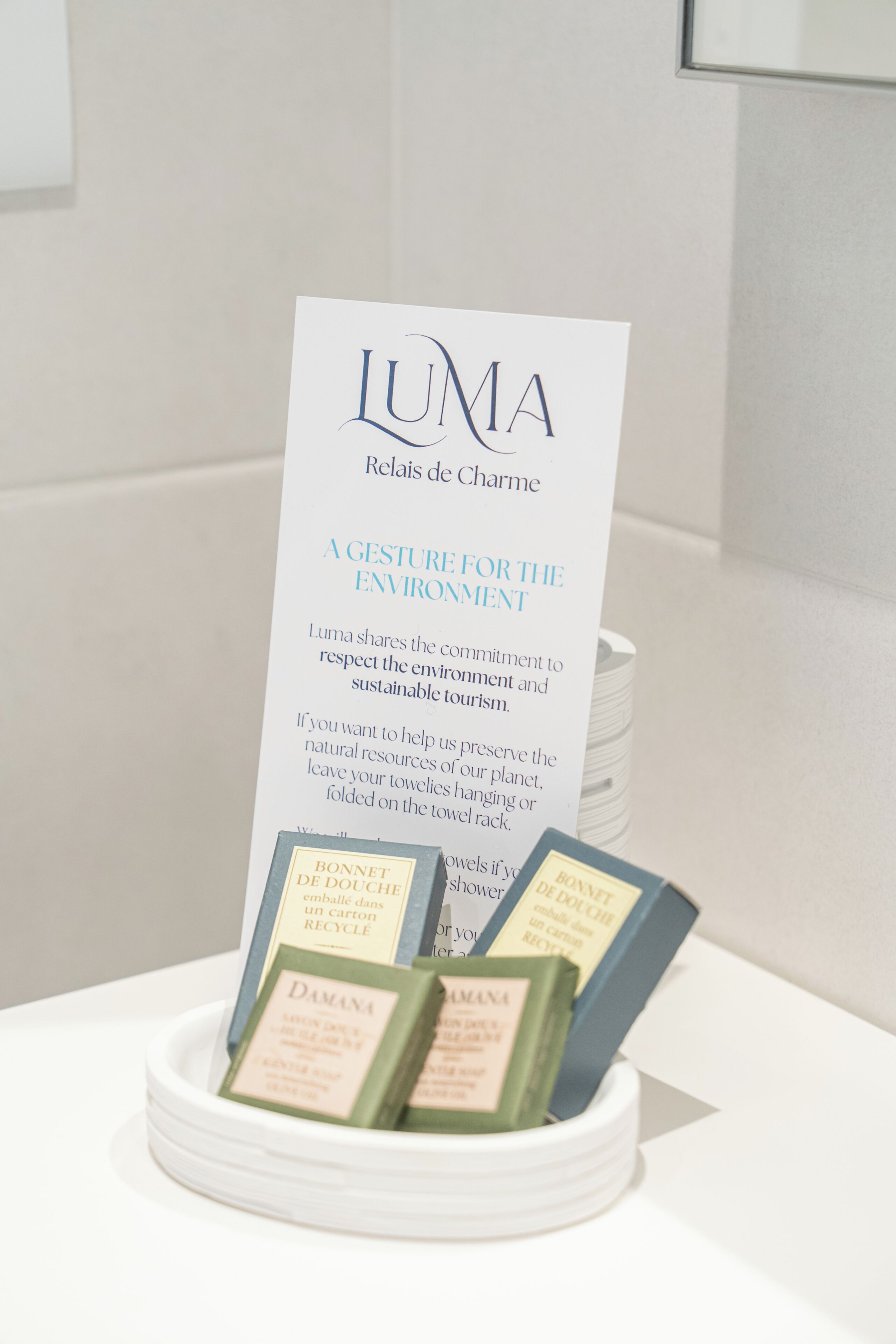 Un cartel con el texto 'LUMA' y 'UN GESTO POR EL MEDIO AMBIENTE' en un entorno hotelero.